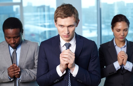 Three business partners asking Lord to help themの写真素材