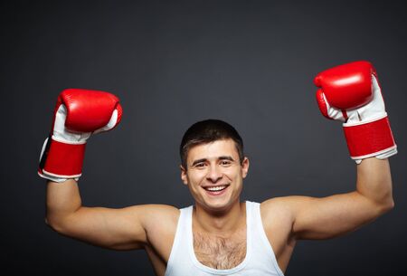 Portrait of happy young man in red boxing gloves looking at cameraの写真素材