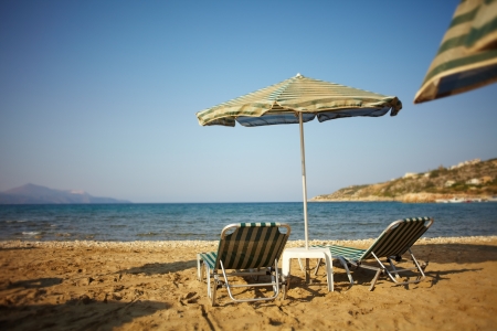 Marine view with a pair of deckchairs and umbrella on the beachの写真素材