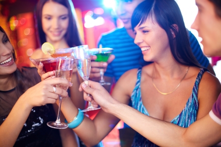 Joyful friends toasting at birthday party with focus on champagne flutesの写真素材