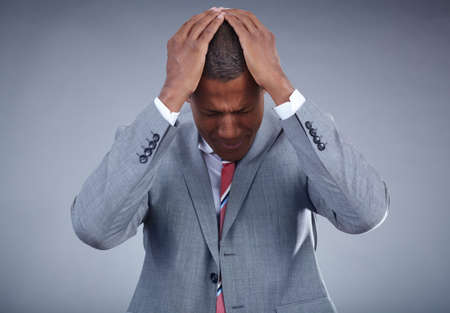 Photo of businessman touching his head on grey backgroundの写真素材