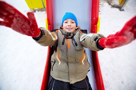 Happy girl in winterwear looking at camera while playing outsideの写真素材