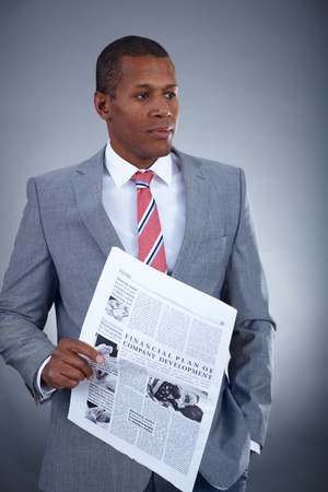 Portrait of successful professional in suit holding newspaperの写真素材