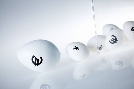 Image of glass containing eggs with euro and yen signsの写真素材