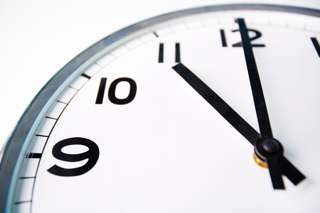 Macro shot of a clock face showing eleven o’clock