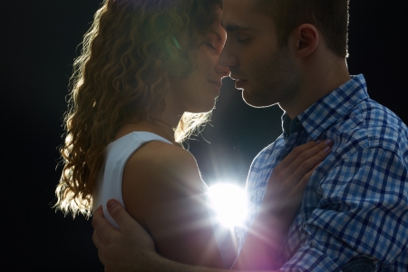 Young couple kissing in the darkの写真素材