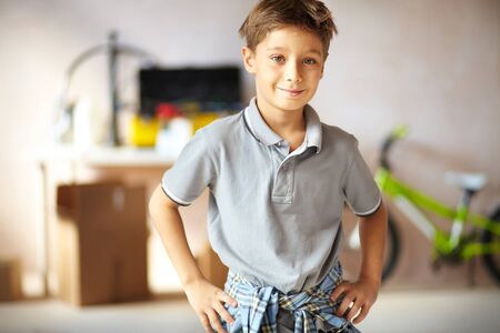 Portrait of cute boy looking at camera in garageの写真素材