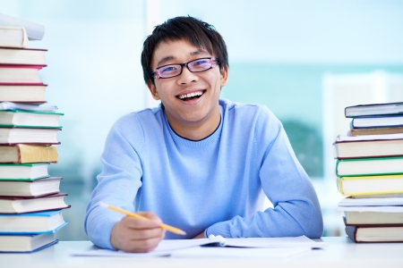 Portrait of successful Asian student sitting at workplaceの写真素材