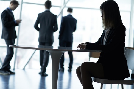 Smart businesswoman at workplace on background of busy employeesの写真素材