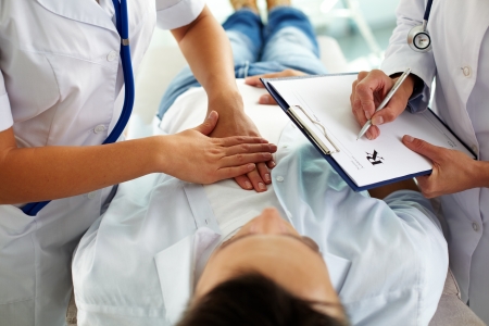 Close-up of two doctors during medical treatment of patient in hospitalの写真素材