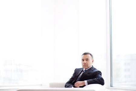 Portrait of pensive businessman sitting in officeの写真素材