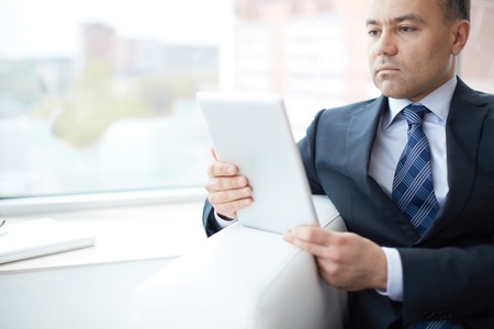 A young serious businessman working with touchpadの写真素材