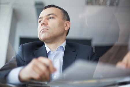 Close-up of businessman face viewed through glass tableの写真素材