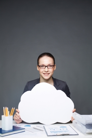 Portrait of young smiling female holding paper speech bubble and looking at cameraの写真素材