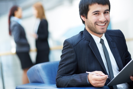Portrait of friendly male leader looking at camera in working environmentの写真素材