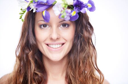 Close-up of happy woman in floral wreath looking at cameraの写真素材
