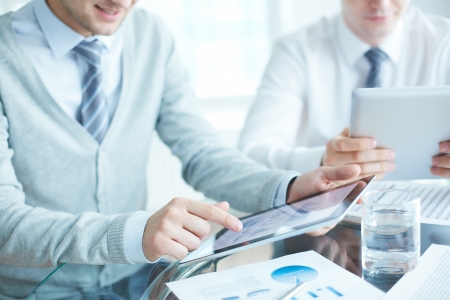 Close-up of businessmen using touchpadsの写真素材