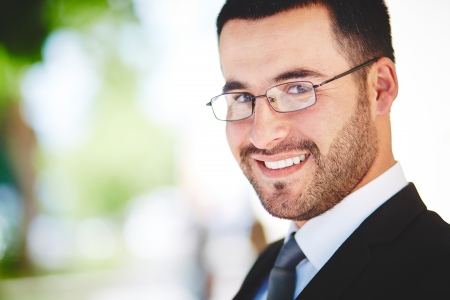 Close-up portrait of a successful business guy smiling ambitiouslyの写真素材