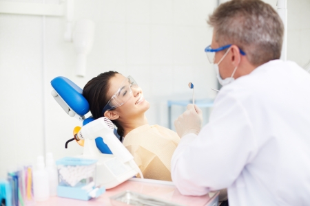 Photo of young smiling female looking at the dentist in the clinicの写真素材