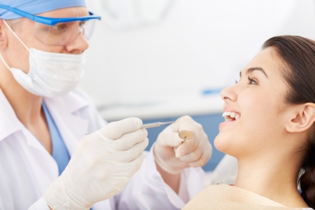 Young girl with open mouth before oral checkup looking at the dentistの写真素材