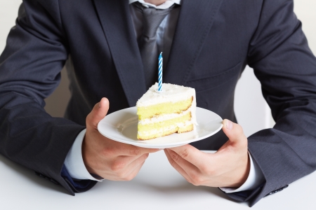 Image of male hands holding saucer with piece of cakeの写真素材