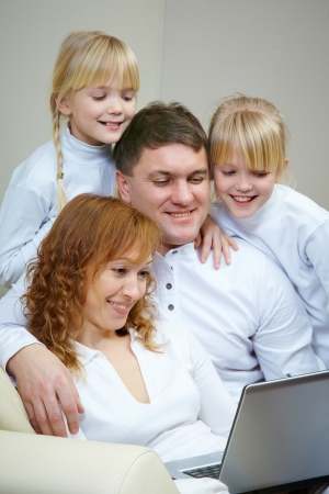Image of friendly family watching film at laptop  の写真素材
