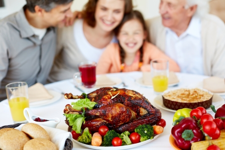 Image of roasted turkey on holiday table and family on backgroundの写真素材