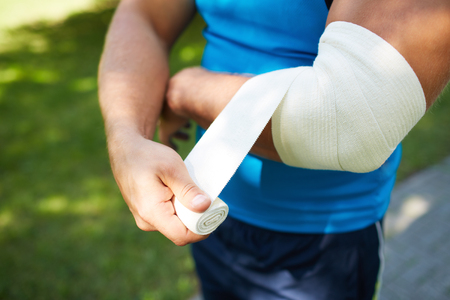 Close-up of male bandaging his armの写真素材