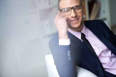 Portrait of attractive male in suit and eyeglasses looking at camera with smileの写真素材