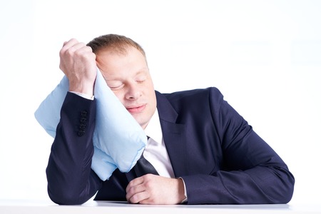 Portrait of calm businessman sleeping on pillow in isolationの写真素材