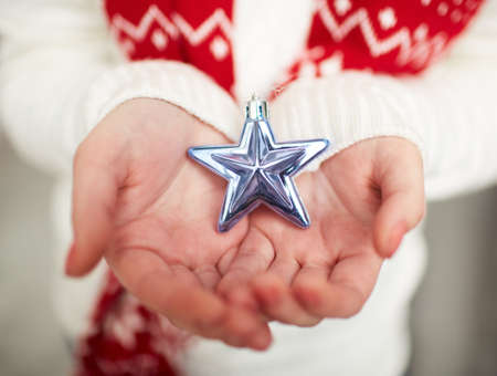 Image of decorative silver toy star on female handsの写真素材