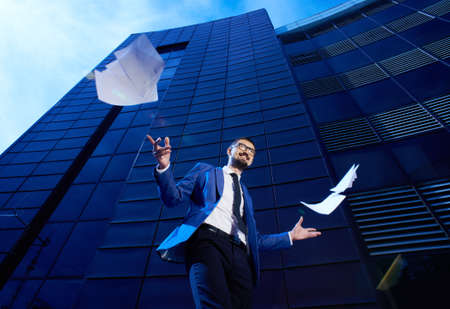 Portrait of ecstatic businessman on background of modern buildingの写真素材