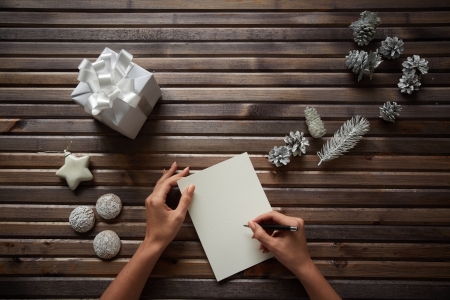 Image of three spice-cakes, decorative silver cones, giftbox and white toy star surrounding female...