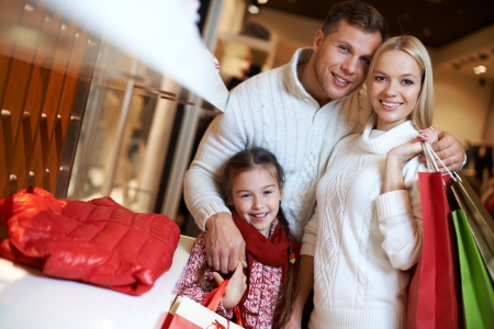 Portrait of young couple and their daughter looking at camera in the mallの写真素材
