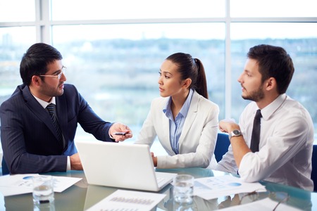 Portrait of three co-workers discussing business ideas in officeの写真素材