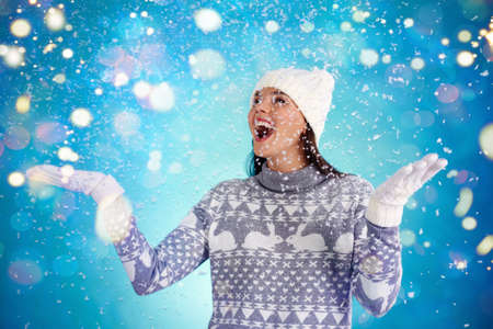 Joyful girl in winterwear enjoying snowfallの写真素材