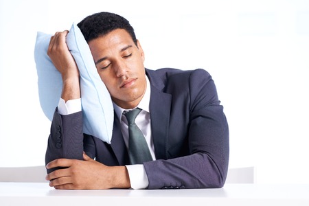 Portrait of smart businessman sleeping on pillow in isolationの写真素材