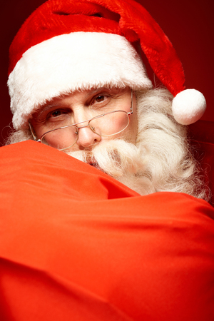 Photo of happy Santa Claus in eyeglasses looking at cameraの写真素材