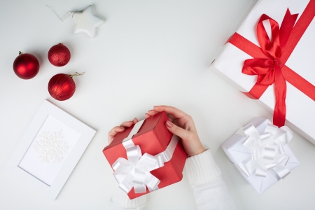 Image of giftbox held by female surrounded by other xmas symbolsの写真素材