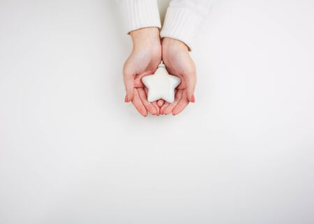 Image of decorative toy star on female hands over white backgroundの写真素材