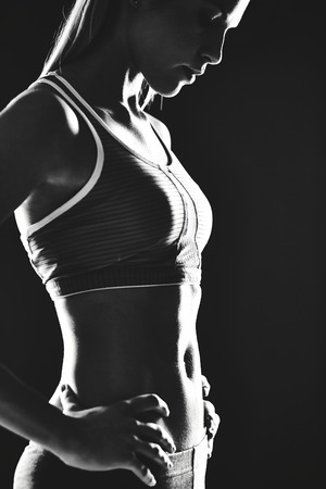 Portrait of slim female in activewear standing in isolationの写真素材