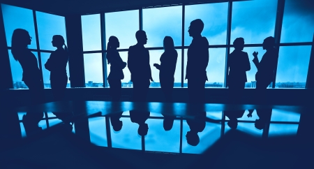 Several colleagues communicating in office against windowの写真素材