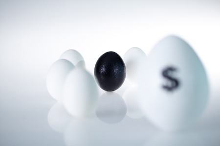 Image of black egg among several other eggsの写真素材