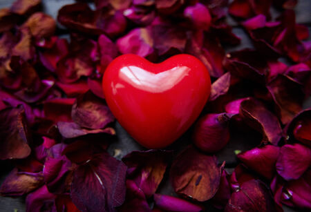 Image of big red heart surrounded by rose petalsの写真素材