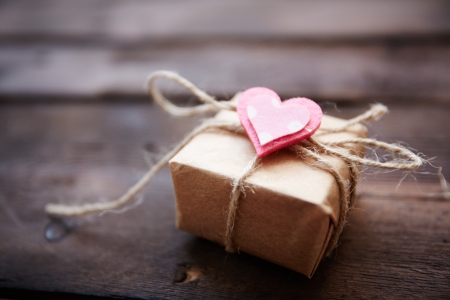 Image of valentine giftbox with small pink heart on wooden backgroundの写真素材