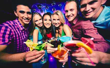 Group of happy friends with cocktails at partyの写真素材