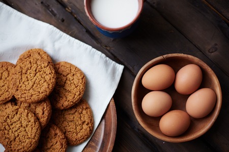 Several eggs in bowl with cup of milk and bisquits near byの写真素材