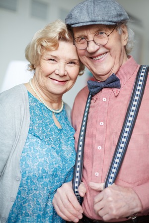 Portrait of retired couple in smart clothes looking at camera