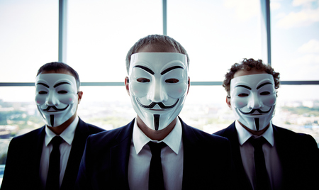 Portrait of three business people wearing anonymous masksのeditorial素材