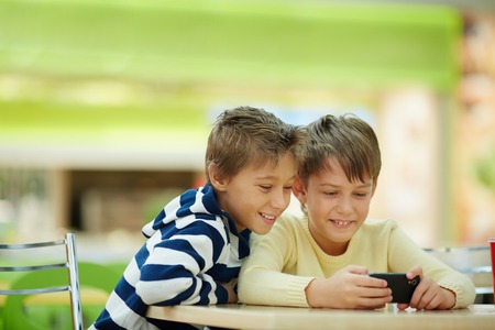Two boys watching smartphone photosの写真素材